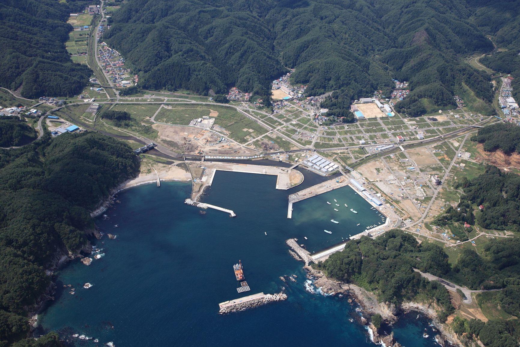 Aerial view of a Japanese coastal harbour, settlement and transport corridors in a reconstructed territorial setting